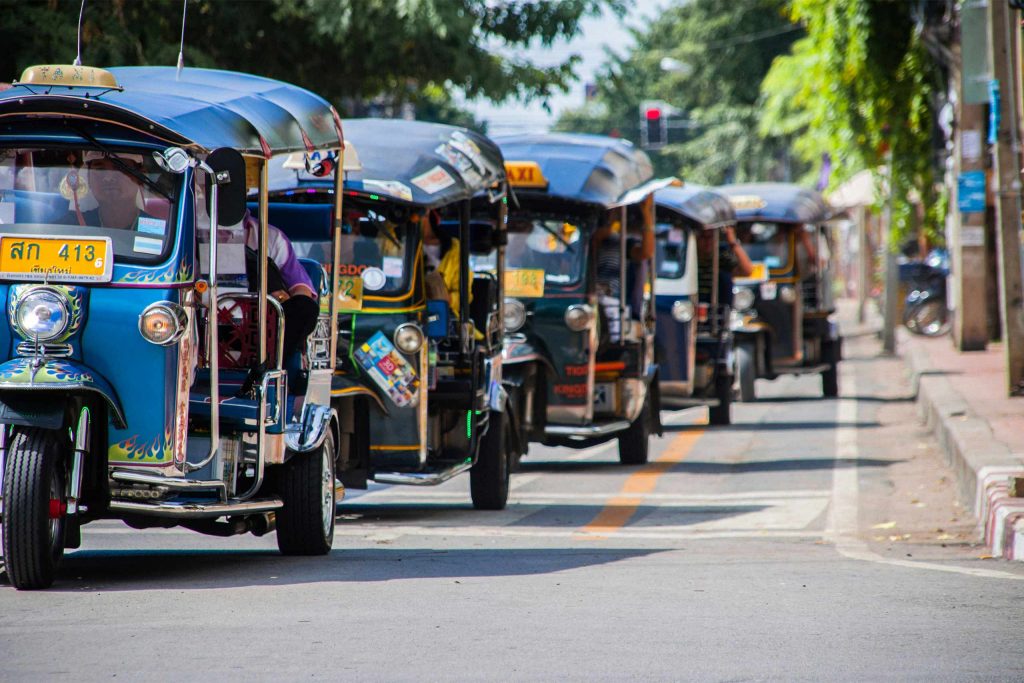 Tuk Tuk vehicles lined up on a street in Chiang Mai.